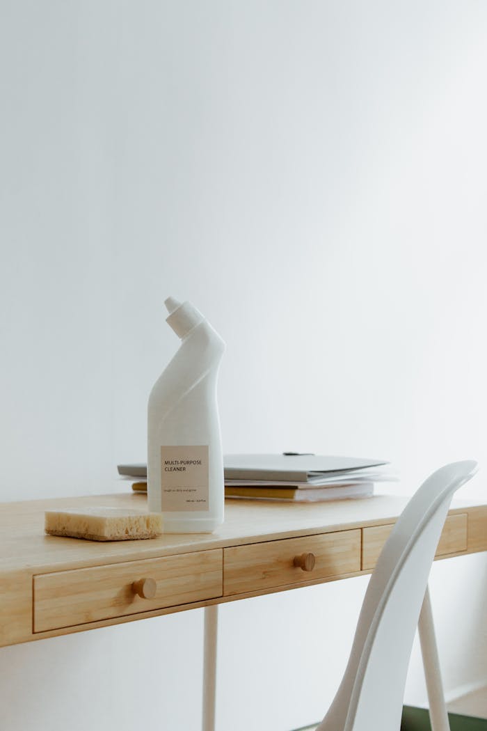about-01 A clean and organized home office desk with a cleaner bottle and sponge, emphasizing simplicity and functionality.